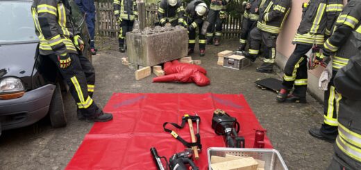 Feuerwehrleute stehen an der Station zur Rettung einer eingeklemmten Person unter einem Betonklotz.