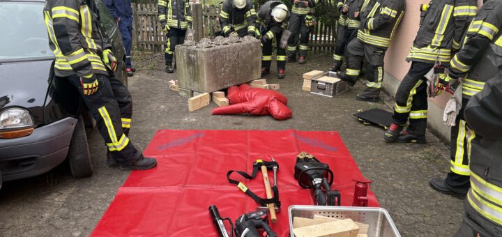 Feuerwehrleute stehen an der Station zur Rettung einer eingeklemmten Person unter einem Betonklotz.