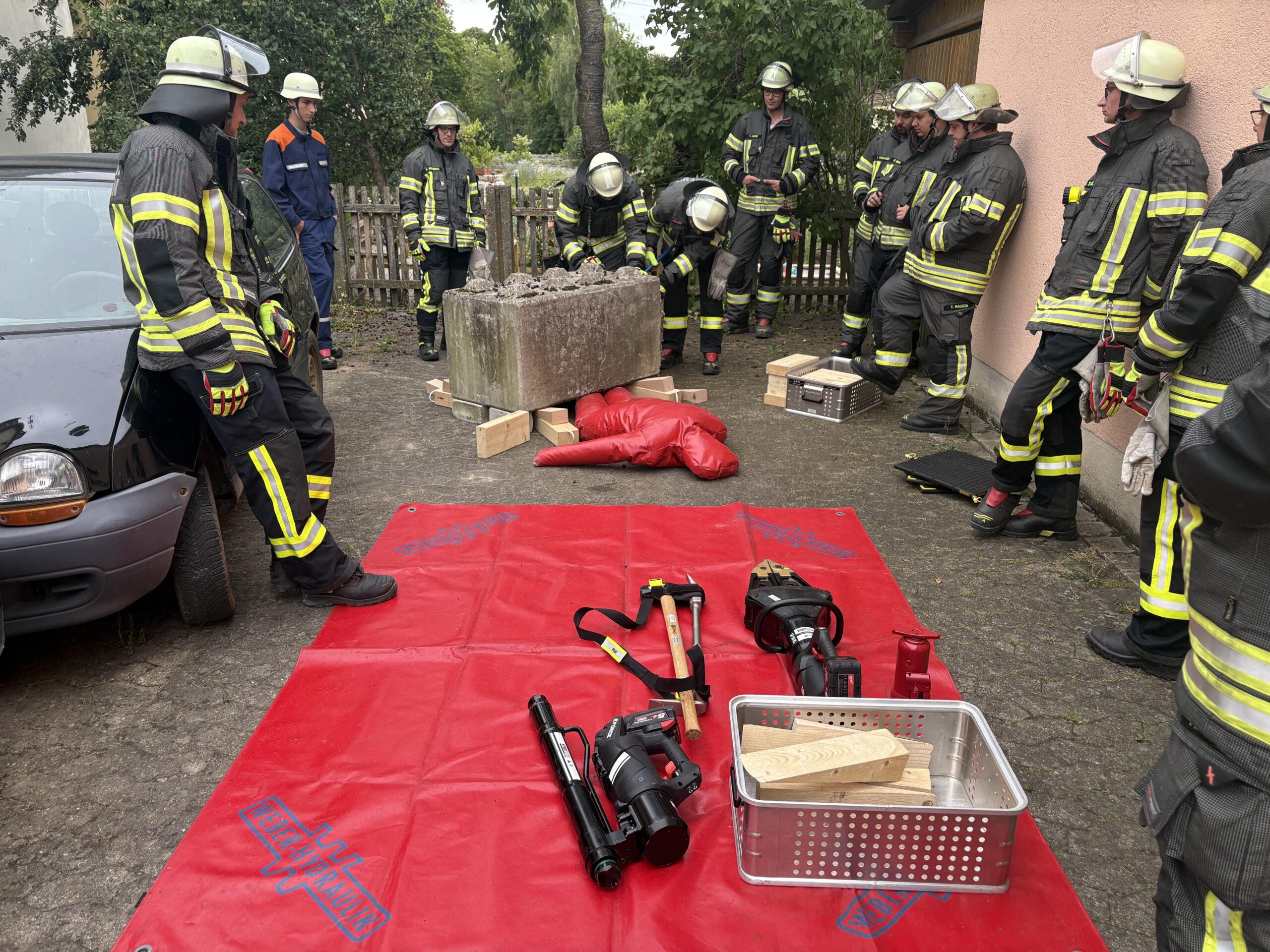 Feuerwehrleute stehen an der Station zur Rettung einer eingeklemmten Person unter einem Betonklotz.